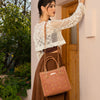 WOMEN IN A IVORY CROCKET CROP TOP AND BROWN SKIRT, CARRYING OUR BROWN GRACIE STRUCTURED TOTE  SET IN A MODERN BACKGROUND. 