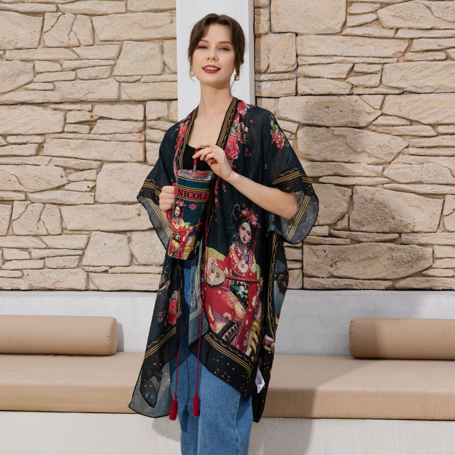 Woman wearing our Akiko La Belleza Kimono and blue jeans while holding the Nicole Lee Akiko la Belleza tumbler set against a modern background.
