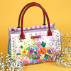 OUR NICOLE LEE SATCHEL BAG  IN DREAMS BLOSSOM DESIGN SET IN A YELLOW BACKGROUND AND WHITE LITTLE FROWERS.