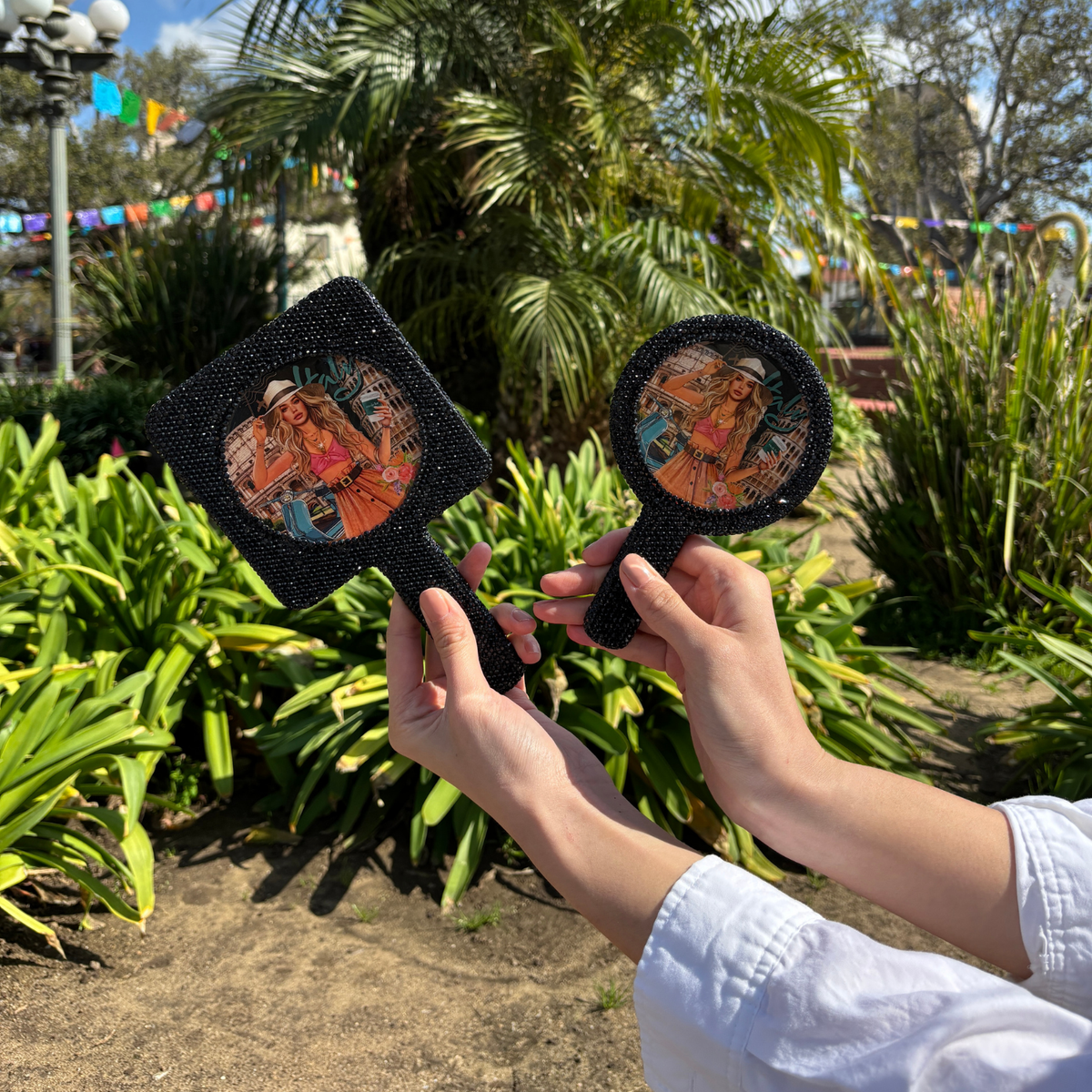 HOLDING OUR RECTANGLE HAND MIRROR AND OUR ROUND MIRROR IN OUR NICOLE LEE MARTHA TRAVELS ITALY DESIGN SET ON  GREENERY BACKGROUND