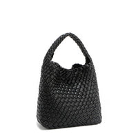 Back angle of Juni handbag crafted in braided vegan leather in classic, timeless black with a top handle (5" drop) and open slip compartment secured with a magnetic snap closure. Slouchy, relaxed silhouette offers a chic and laid-back yet refined look.