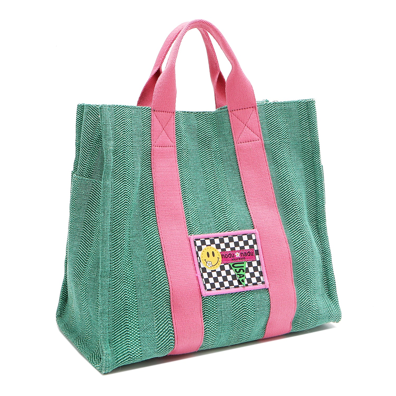 Front angle view of the Nodu Nadu Sawyer Bag in Green. Crafted in durable canvas with side D-rings for optional shoulder strap attachment so you can wear this bag as a handbag, shoulder bag, or crossbody! It also features side slip pockets for a convenient touch. 