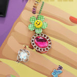 OUR NAIL POLISH HOBO BAG FRONT IS EMBELLISHED WITH RESIN FLOWERS, GEMS, AND JEWELS