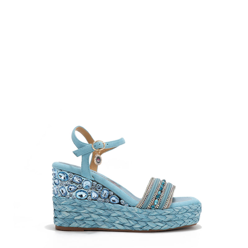 Kali Espadrille Wedge sandal in blue.  Fitted with 1 adjustable buckle. The buckle has a small Nicole Lee Charm.The wedge is adorned with rhinestones and  braid detailing.