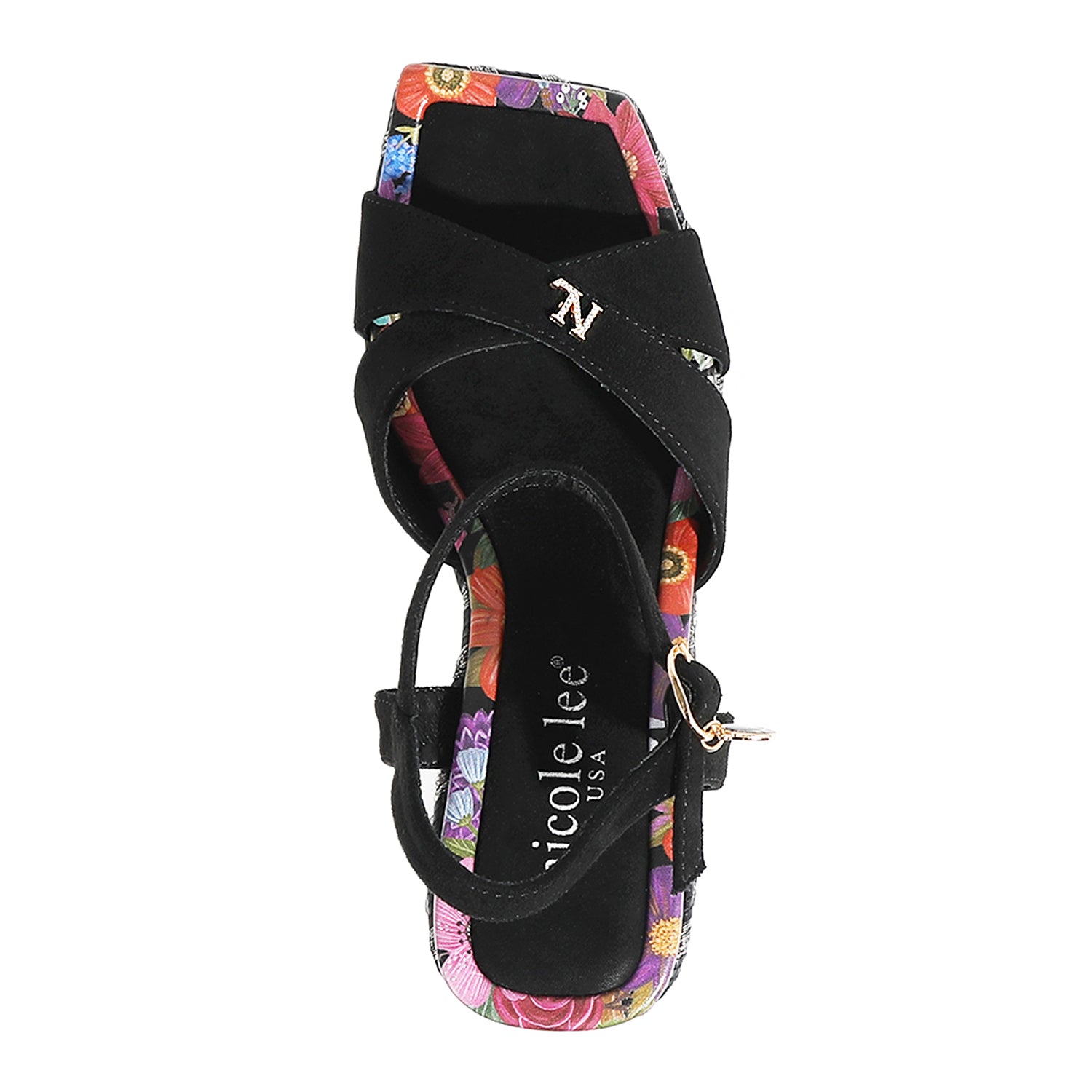 THE SANDAL FROM A VIEW FROM ABOVE. THE CRISSCROSS STRAPS WITH THE NL INITIALS IN THE MIDDLE. THE BLACK INSOLE WITH FLORAL PRINT ON THE EDGES.